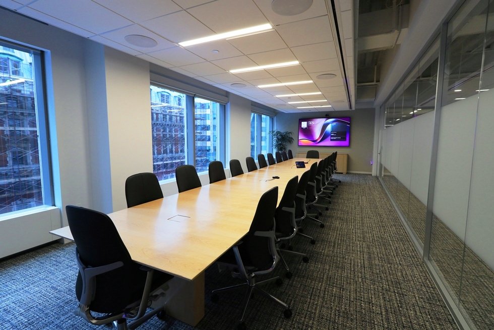 The clean and minimalist boardroom for local and international meetings is supported by a fully integrated AV and telecom system. The sleek light wood custom table comfortably seats twenty-two.